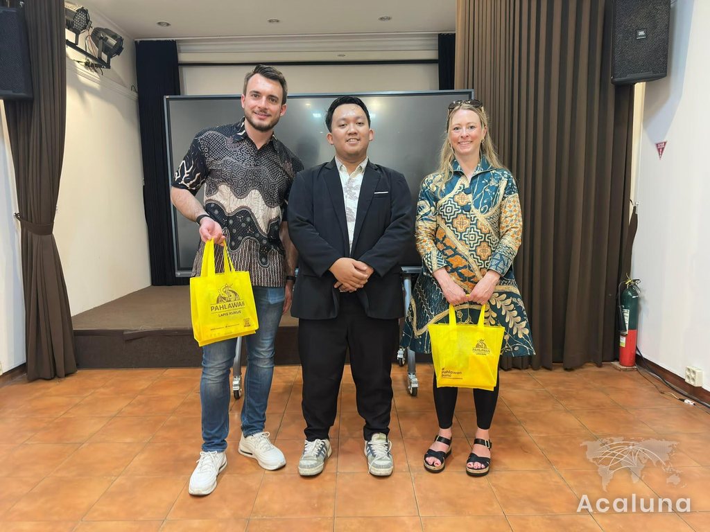 Dr. Manuel Behmüller and Jessica Moll wearing batik with an apprentice at an event